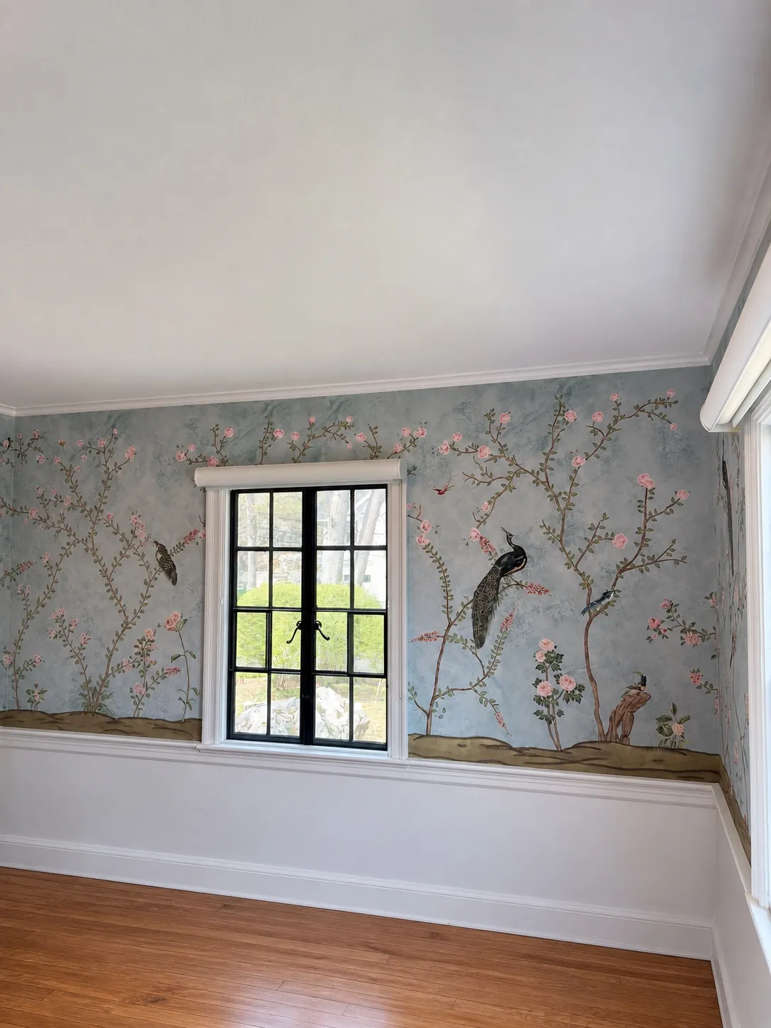 Professional wallpaper installer working on a patterned wall