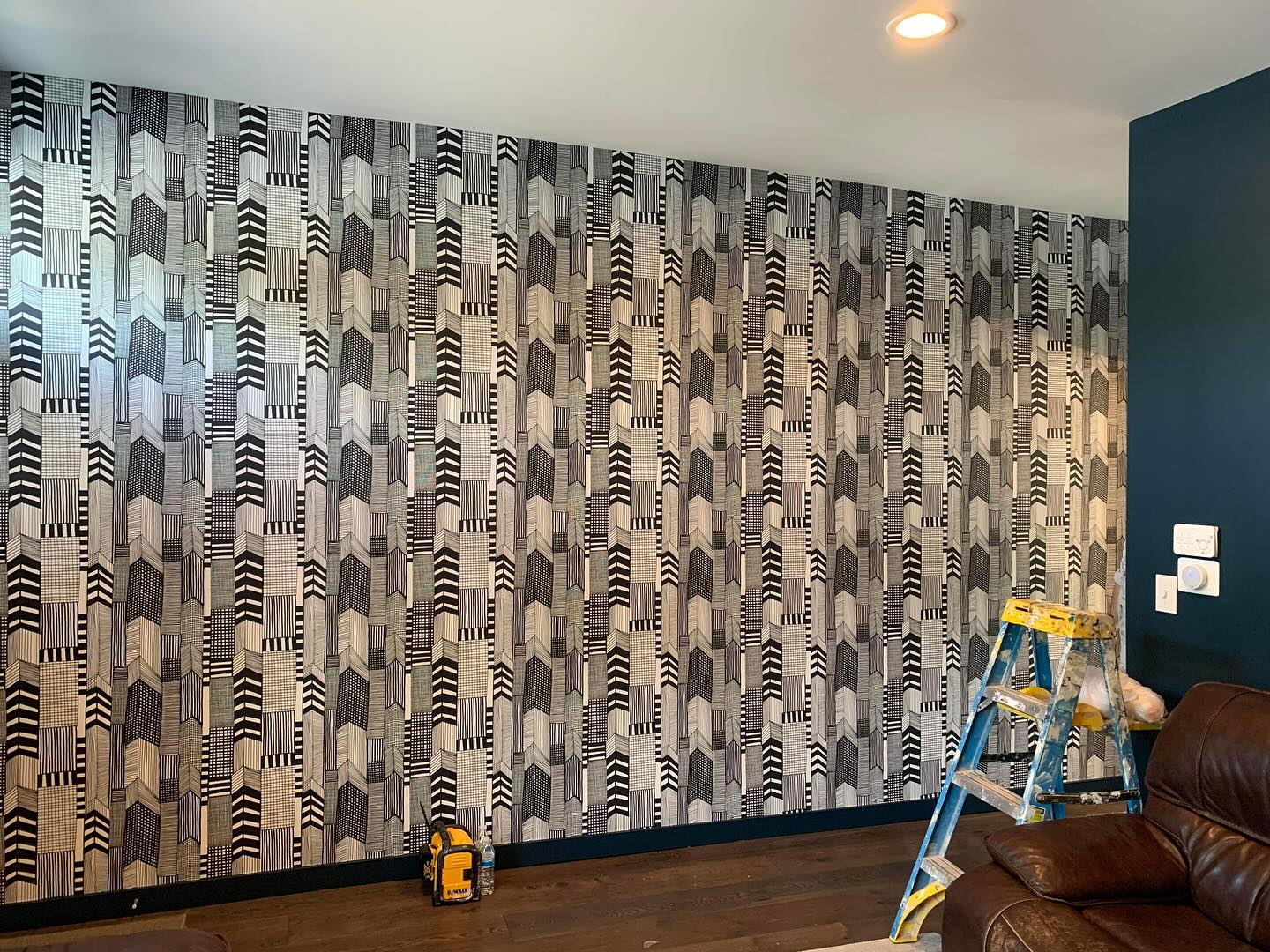 Geometric wallpaper installed across a finished interior wall